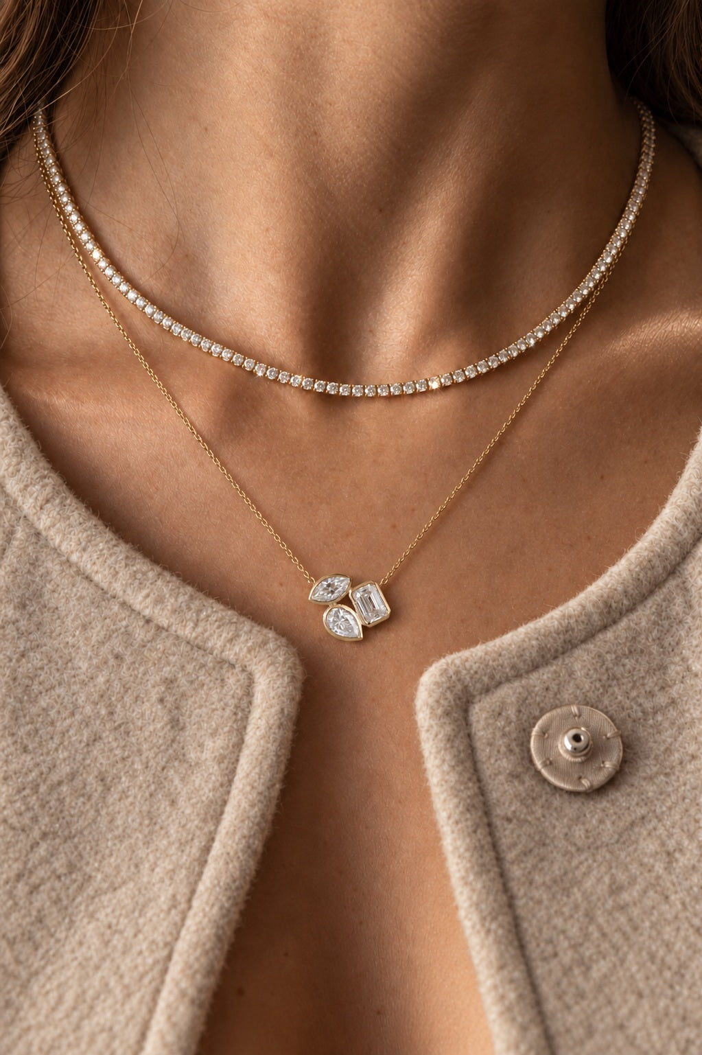 Three-stone diamond pendant on a fine gold chain, layered with a tennis necklace