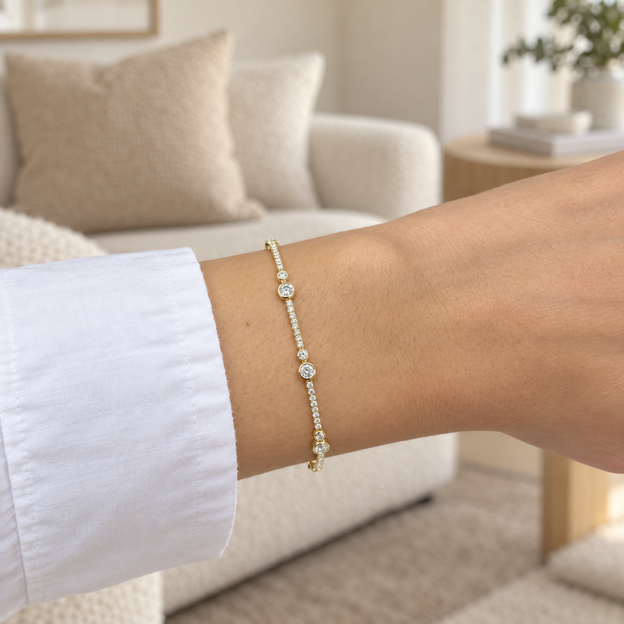 Bezel and pavé diamond bracelet in yellow gold worn on a wrist