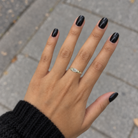 East-west emerald diamond signet ring worn on a hand