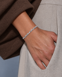 Emerald-cut and round lab-grown diamond tennis bracelet in white gold worn on a wrist
