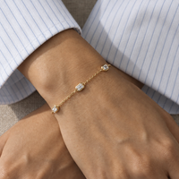 Emerald-cut diamond station bracelet in yellow gold worn on a wrist