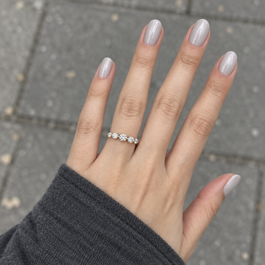 Graduated five stone diamond ring in yellow gold worn on a hand