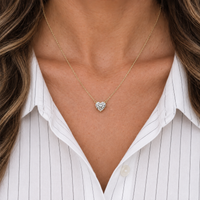 Heart diamond necklace in yellow gold worn with a white shirt