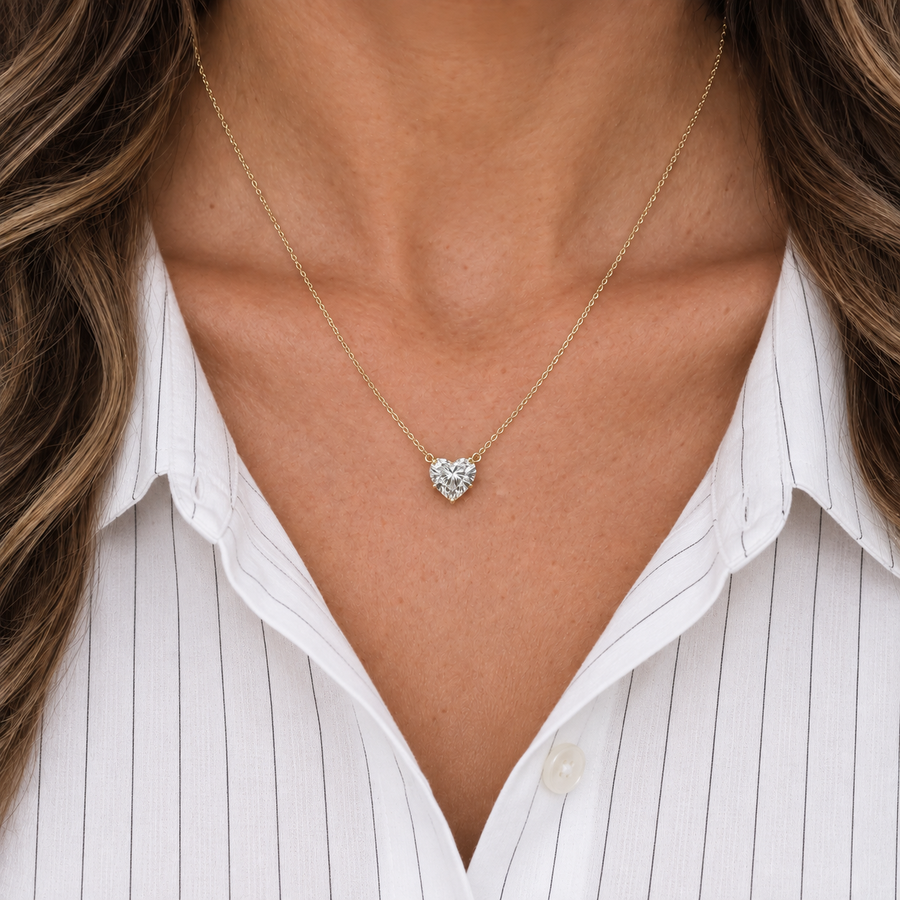 Heart diamond necklace in yellow gold worn with a white shirt