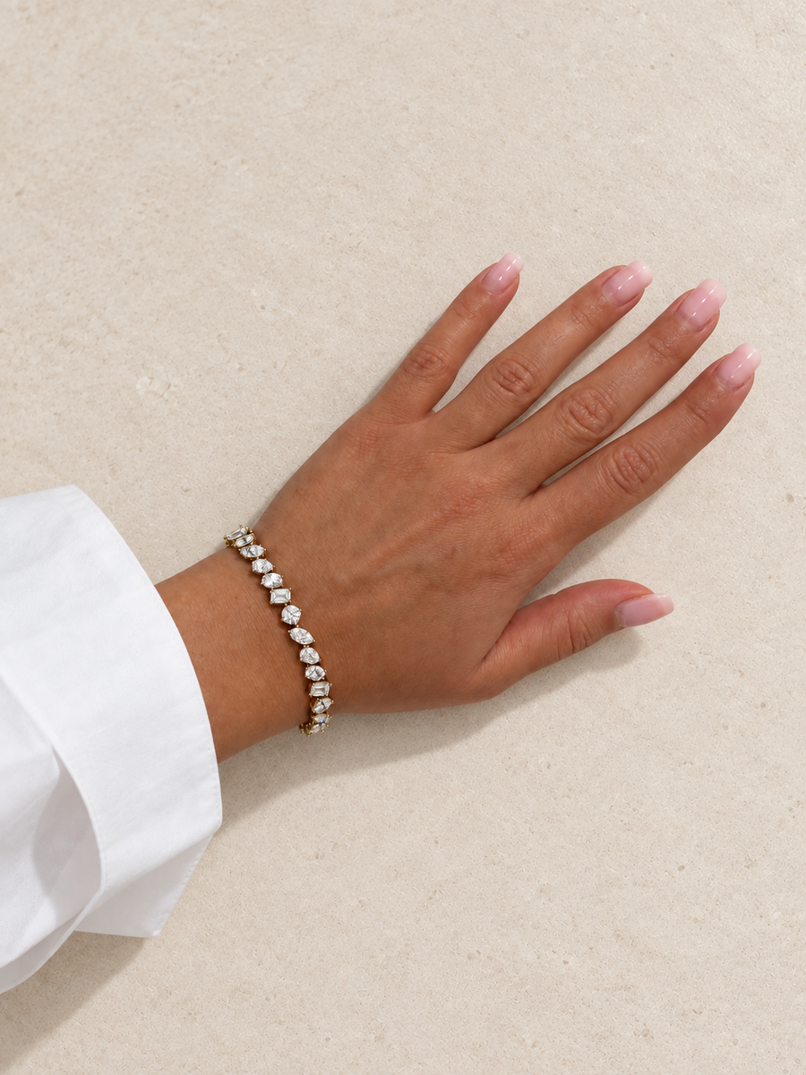Mixed shape diamond tennis bracelet in yellow gold worn on the wrist