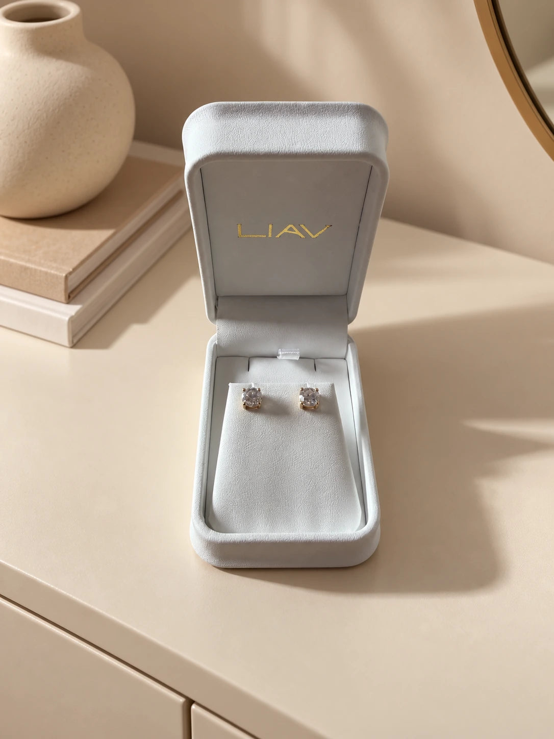 Diamond stud earrings in a LIAV jewellery box on a neutral dressing table