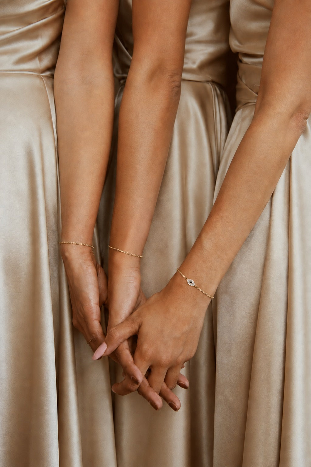 Three bridesmaids wearing matching gold bracelets