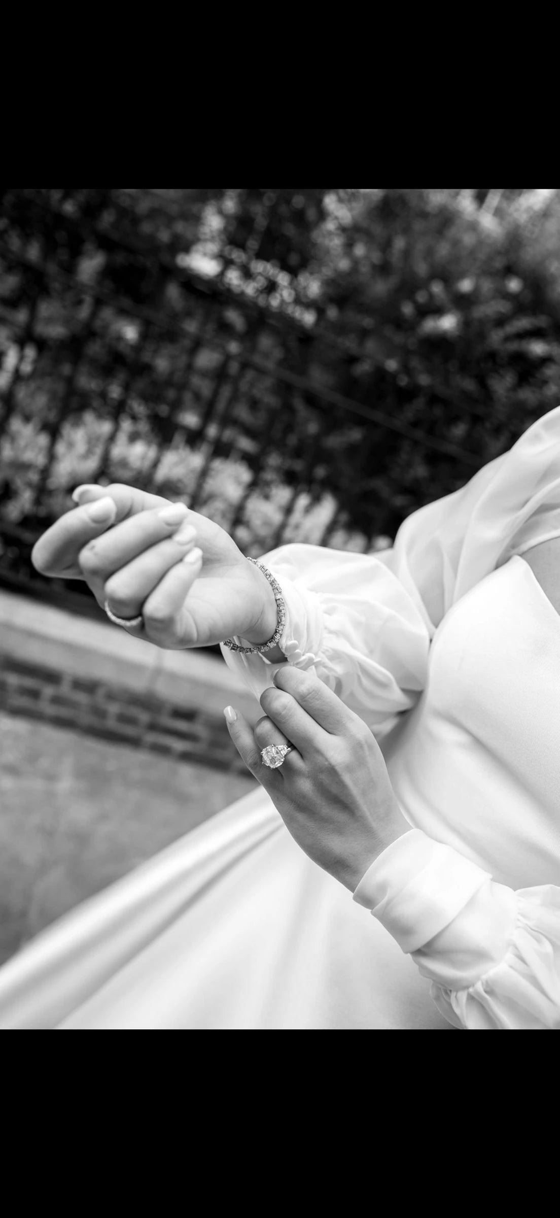 Bride adjusting her bracelet, wearing a diamond engagement ring