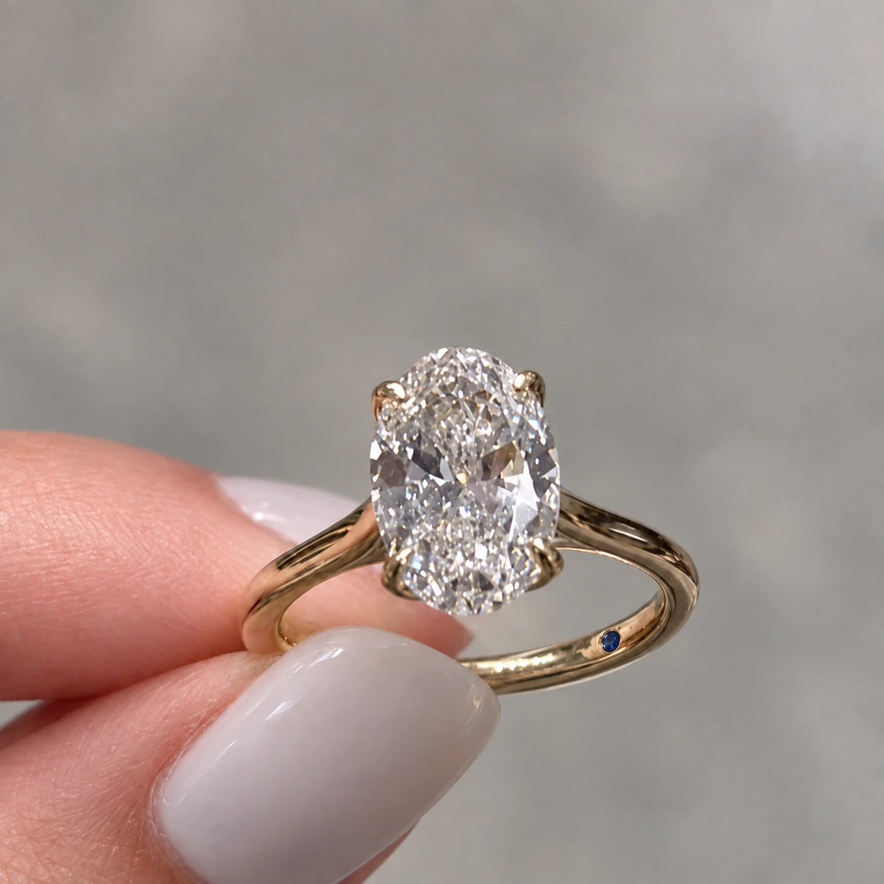 A blue sapphire set inside a gold engagement ring