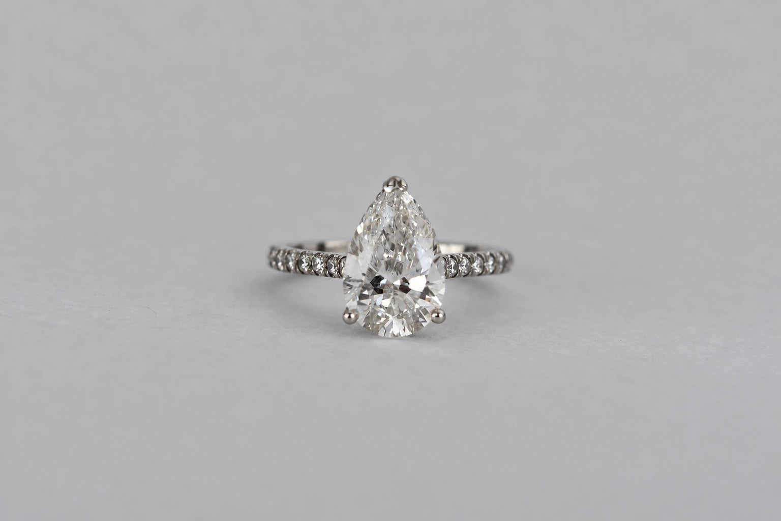 Front view of the client’s pear-shaped diamond ring in platinum